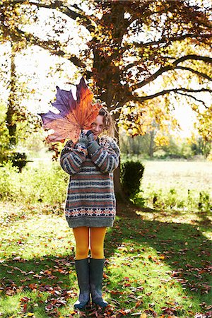 Girl playing with autumn leaf outdoors Fotografie stock - Premium Royalty-Free, Codice: 6113-06720222