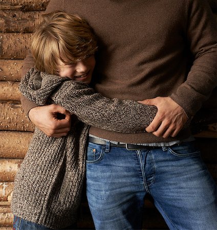 parents and child hugging - Smiling son hugging father Stock Photo - Premium Royalty-Free, Code: 6113-06720235