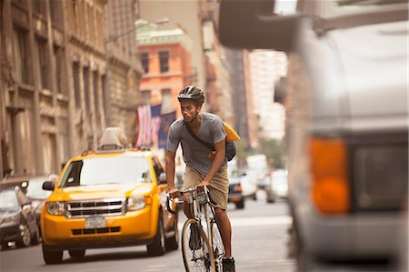 simsearch:6113-06720509,k - Man riding bicycle on city street Photographie de stock - Premium Libres de Droits, Code: 6113-06720341