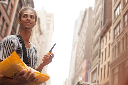 delivery (goods and services) - Man carrying mail on city street Stock Photo - Premium Royalty-Free, Code: 6113-06720380