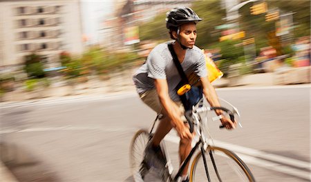 simsearch:6113-06720509,k - Man riding bicycle on city street Photographie de stock - Premium Libres de Droits, Code: 6113-06720388