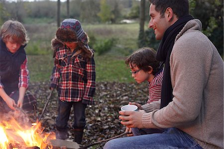 fall campfire - Father and children sitting around bonfire Stock Photo - Premium Royalty-Free, Code: 6113-06720304