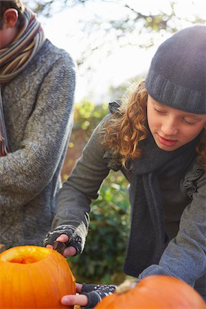 pumpkin carving - Children carving pumpkins together outdoors Stock Photo - Premium Royalty-Free, Code: 6113-06720310