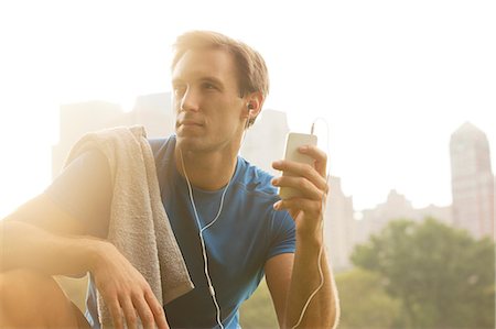 Runner listening to mp3 player in park Stock Photo - Premium Royalty-Free, Code: 6113-06720335