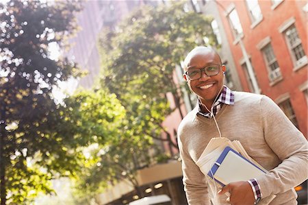 portrait bald men with glasses - Man listening to earphones on city street Stock Photo - Premium Royalty-Free, Code: 6113-06720446