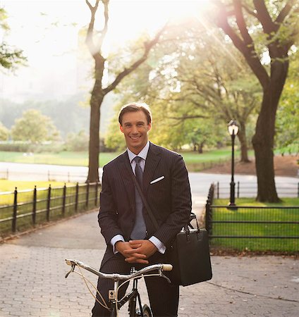 simsearch:6113-06720509,k - Businessman sitting on bicycle in urban park Photographie de stock - Premium Libres de Droits, Code: 6113-06720498