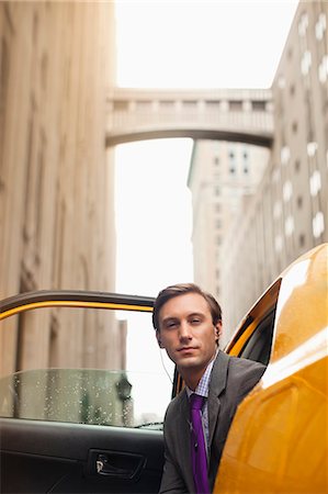 Businessman climbing out of taxi Stock Photo - Premium Royalty-Free, Code: 6113-06720550