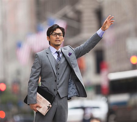 Businessman hailing taxi on city street Stock Photo - Premium Royalty-Free, Code: 6113-06720531