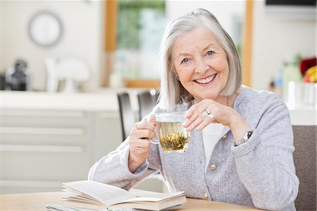 portrait woman senior 70 years old casual clothes not asian not hispanic - Older woman drinking tea and reading Stock Photo - Premium Royalty-Free, Code: 6113-06720658