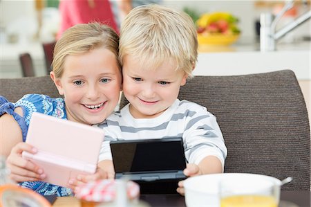family playing games indoors - Children playing video games at breakfast Stock Photo - Premium Royalty-Free, Code: 6113-06720681