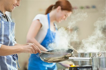 simsearch:6113-06720709,k - Couple cooking in kitchen Photographie de stock - Premium Libres de Droits, Code: 6113-06720687