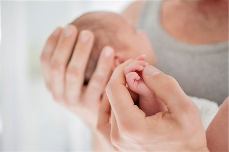 devoción - Mother cradling newborn baby's hand Foto de stock - Sin royalties Premium, Código: 6113-06720606