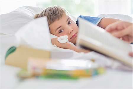 Sick boy laying in bed Stock Photo - Premium Royalty-Free, Code: 6113-06720637