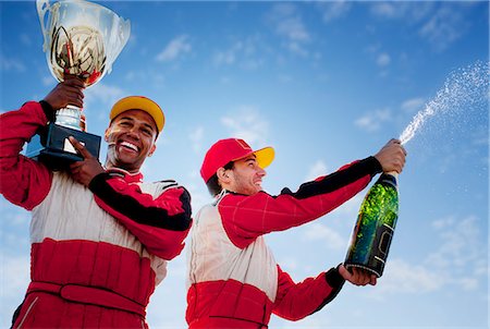 Racers holding trophy and champagne Stock Photo - Premium Royalty-Free, Code: 6113-06720779