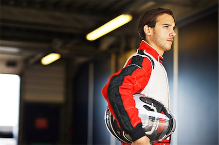 Racer holding helmet in garage Foto de stock - Sin royalties Premium, Código: 6113-06720786