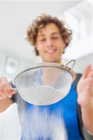 simsearch:6113-06720694,k - Man sifting flour in kitchen Stock Photo - Premium Royalty-Free, Code: 6113-06720717