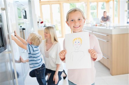 Girl showing off drawing in kitchen Photographie de stock - Premium Libres de Droits, Code: 6113-06720723