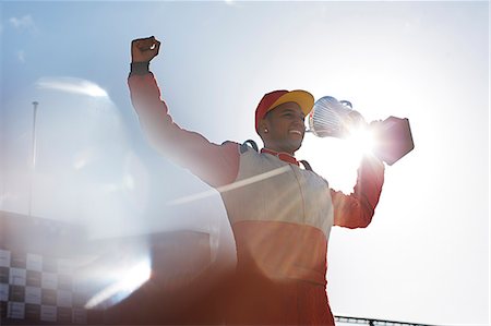 Cheering racer holding trophy on track Foto de stock - Sin royalties Premium, Código: 6113-06720732