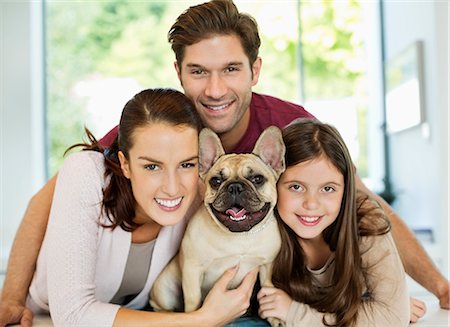 dog portraits - Smiling family hugging dog Stock Photo - Premium Royalty-Free, Code: 6113-06720862