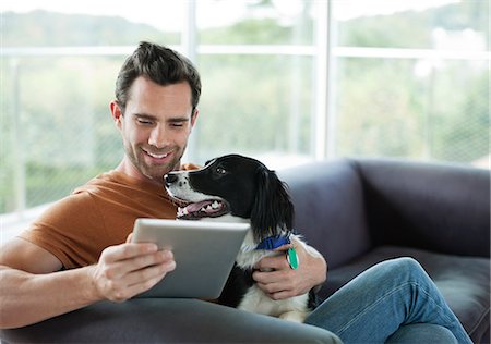 spaniel - Man petting dog and using tablet computer Foto de stock - Sin royalties Premium, Código: 6113-06720898