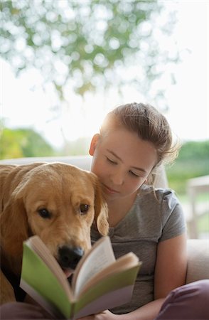 Girl reading with dog in armchair Foto de stock - Sin royalties Premium, Código: 6113-06720968