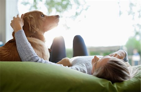 Woman petting dog on bed Photographie de stock - Premium Libres de Droits, Code: 6113-06720973