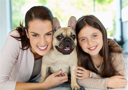 Smiling mother and daughter hugging dog Foto de stock - Sin royalties Premium, Código: 6113-06720988
