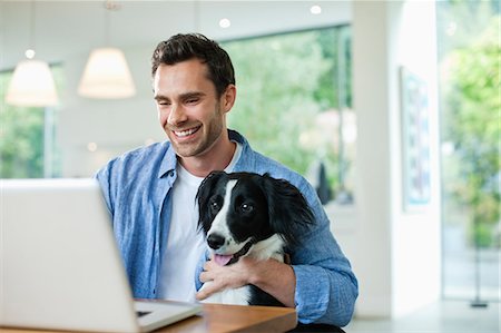 pet owners and their pets - Man with dog on lap using laptop Stock Photo - Premium Royalty-Free, Code: 6113-06720994