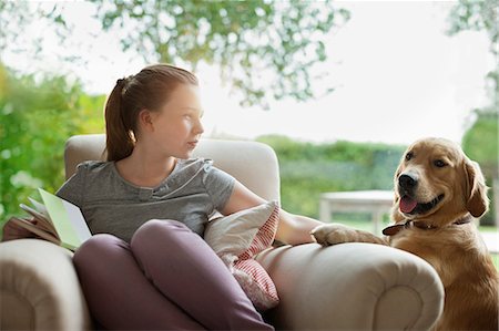 Girl relaxing with dog in armchair Stock Photo - Premium Royalty-Free, Code: 6113-06720912