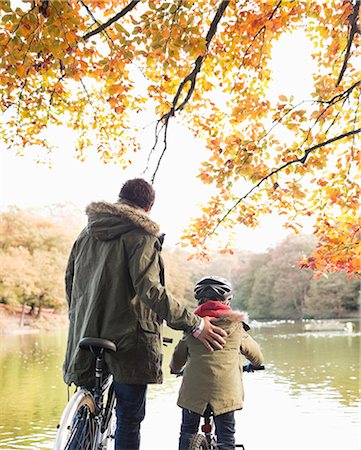 Father and son riding bicycles in park Stock Photo - Premium Royalty-Free, Code: 6113-06721142