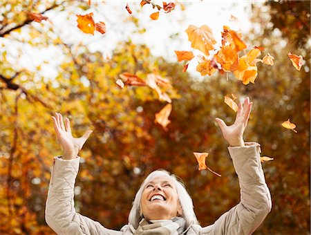 fun play move - Older woman playing in autumn leaves Stock Photo - Premium Royalty-Free, Code: 6113-06721164
