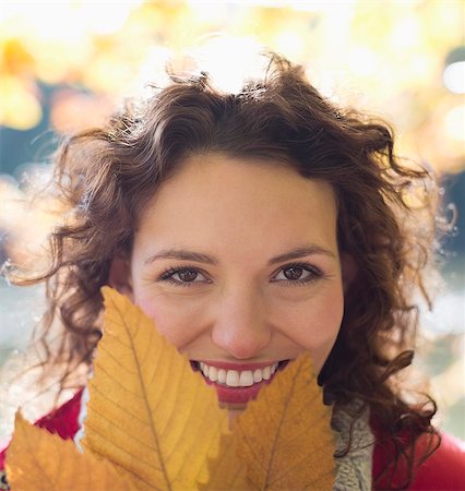 fall leaves - Smiling woman holding autumn leaf Stock Photo - Premium Royalty-Free, Code: 6113-06721181