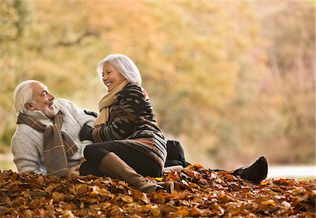 Older couple sitting in autumn leaves Photographie de stock - Premium Libres de Droits, Code: 6113-06721182