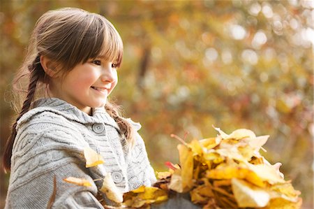 fall kids - Smiling girl playing in autumn leaves Stock Photo - Premium Royalty-Free, Code: 6113-06721188