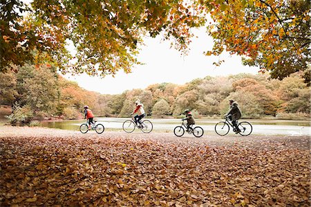 daughter riding on mother - Family riding bicycles in park Stock Photo - Premium Royalty-Free, Code: 6113-06721129