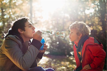 exhaling - Father and son blowing bubbles in park Foto de stock - Sin royalties Premium, Código: 6113-06721139