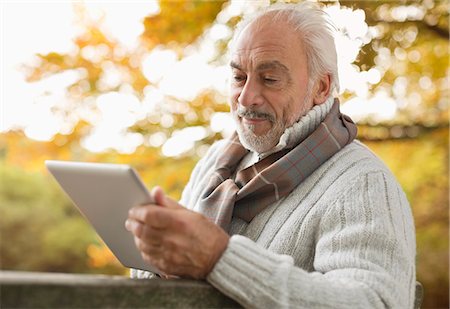 seniors lifestyle fall - Older man using tablet computer in park Stock Photo - Premium Royalty-Free, Code: 6113-06721270