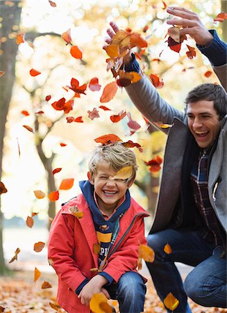 Father and son playing in autumn leaves Foto de stock - Sin royalties Premium, Código: 6113-06721282