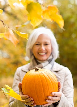 simsearch:6113-06721322,k - Older woman holding pumpkin in park Foto de stock - Royalty Free Premium, Número: 6113-06721291