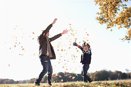 fall leaves - Father and son playing in autumn leaves Stock Photo - Premium Royalty-Free, Code: 6113-06721221