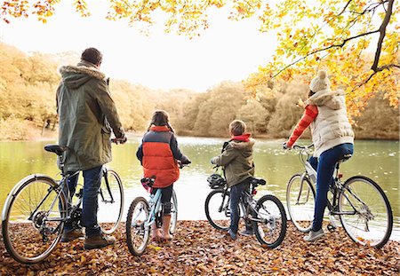 Family sitting on bicycles together in park Stock Photo - Premium Royalty-Free, Code: 6113-06721235