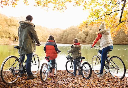 family on bikes - Family sitting on bicycles together in park Photographie de stock - Premium Libres de Droits, Code: 6113-06721235