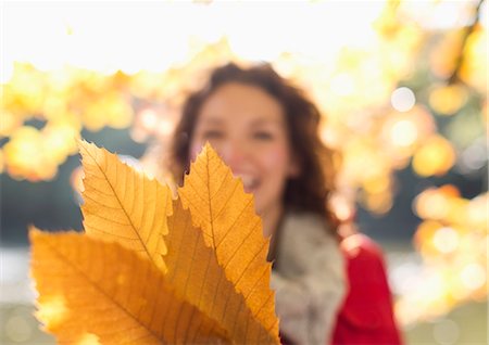 simsearch:6113-06721322,k - Woman holding autumn leaves in park Stockbilder - Premium RF Lizenzfrei, Bildnummer: 6113-06721302