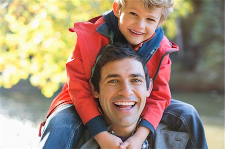 father and son amusement park - Father carrying son on shoulders in park Stock Photo - Premium Royalty-Free, Code: 6113-06721314