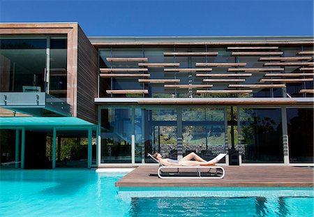 Woman sunbathing on lounge chair at poolside Foto de stock - Sin royalties Premium, Código: 6113-06898782