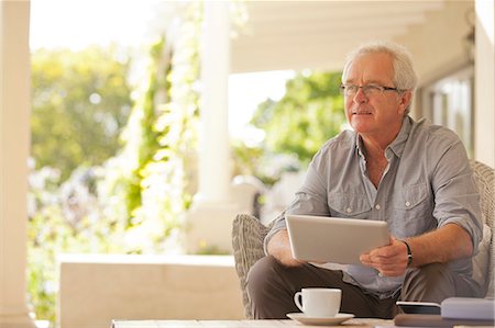 senior man digital tablet - Smiling man using digital tablet on porch Stock Photo - Premium Royalty-Free, Code: 6113-06898870