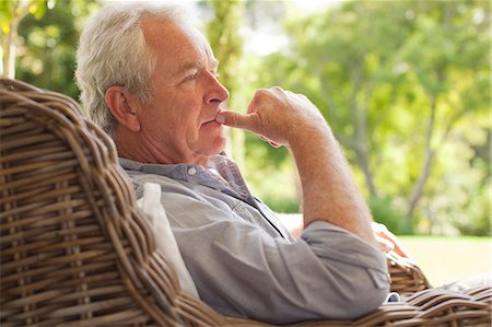 Pensive senior man sitting in wicker armchair on porch Foto de stock - Sin royalties Premium, Código: 6113-06898876