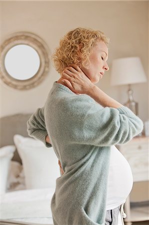 Pregnant woman holding neck and back in pain Photographie de stock - Premium Libres de Droits, Code: 6113-06898899