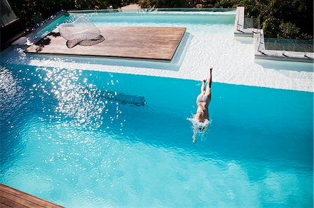 Woman diving in luxury swimming pool Foto de stock - Sin royalties Premium, Código: 6113-06898836