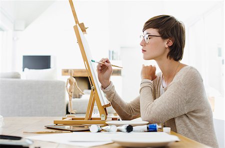 Woman painting on easel at table Photographie de stock - Premium Libres de Droits, Code: 6113-06898946